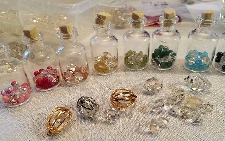Small vials with Herkimer diamonds, various color beads and Swarovski crystals. 

(Plus some Herkimer diamonds in cages on table to be hung on necklace cord).
Art Rains